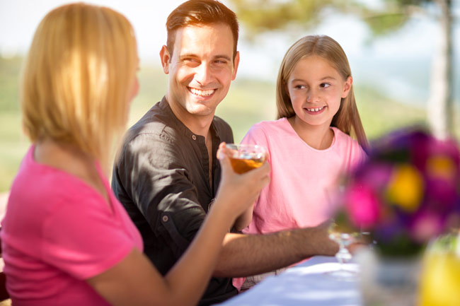 Family Enjoying A Meal Outdoors
